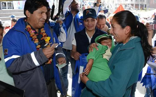 Una madre recibe de manos del Ministro de Salud el bono Juana Azurduy de Padilla.