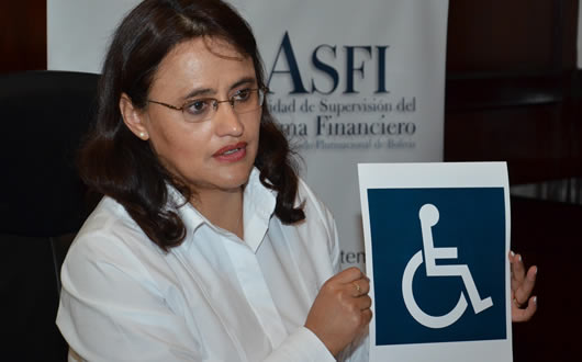 Lenny Valdivia, directora de la ASFI muestra la señal universal de discapacitados