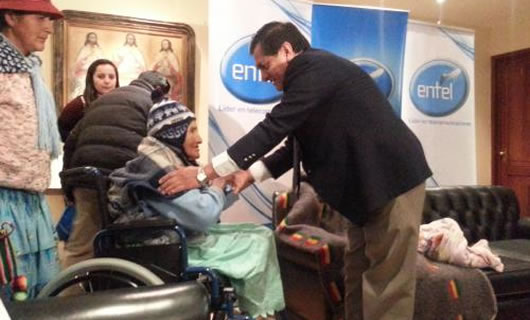 El gerente de Entel, Óscar Coca, hace entrega de una silla de ruedas