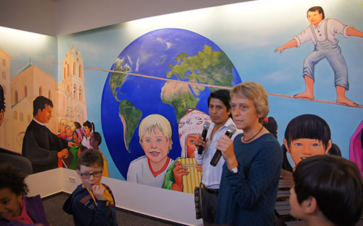 Personal de la institución alemana durante la presentación del mural, detrás el artista y la obra.