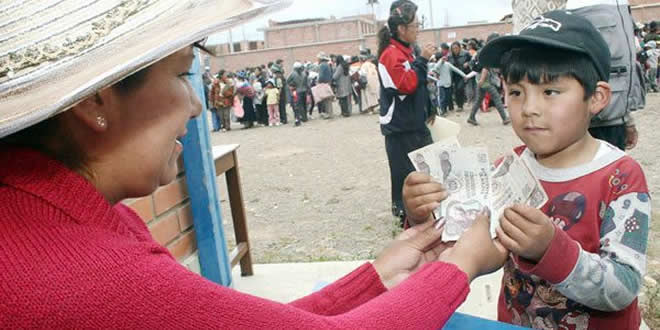 Un niño recibe su bono en El Alto.