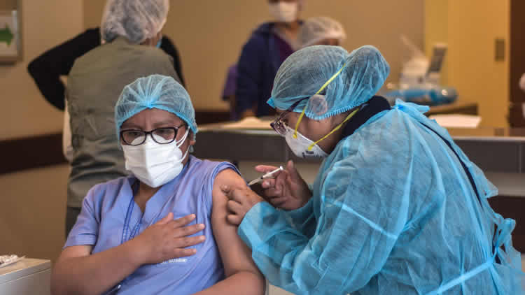 Trabajador recibe la vacuna anticovid.