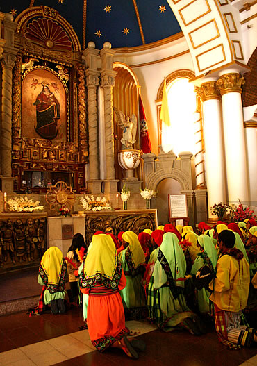Los devotos al pie de la Virgen del Socavón a la que ofrecen el sacrificio de su baile en la entrada del Carnaval de Oruro.