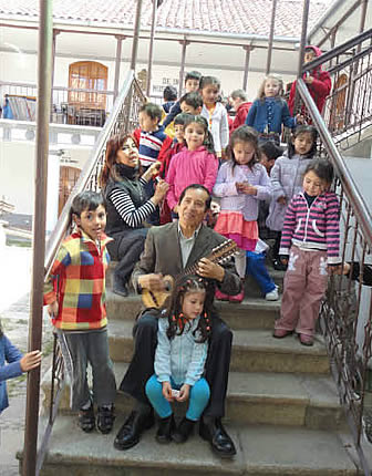 Grupo de niños con el maestro de charango Ernesto Cavour