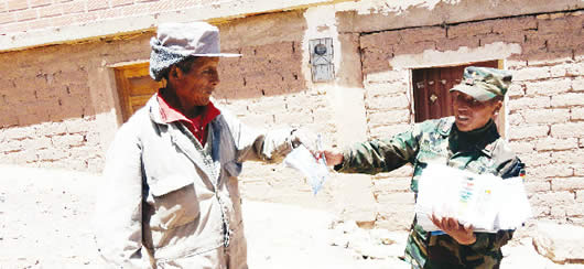 Soldado entrega cartilla informativa del acto electoral.