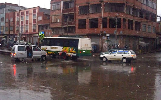 Vehículos circulan por las calles bajo la lluvia en la ciudad de El Alto.