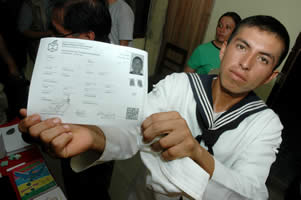 El conscripto Elio Zarzuri Pacasi muestra su certificado de inscripción en el padrón biométrico después de registrarse en Rurrenabaque. 
