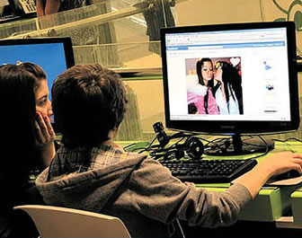 Dos adolescentes revisan su facebook, red social en la que comparten sus actividades
