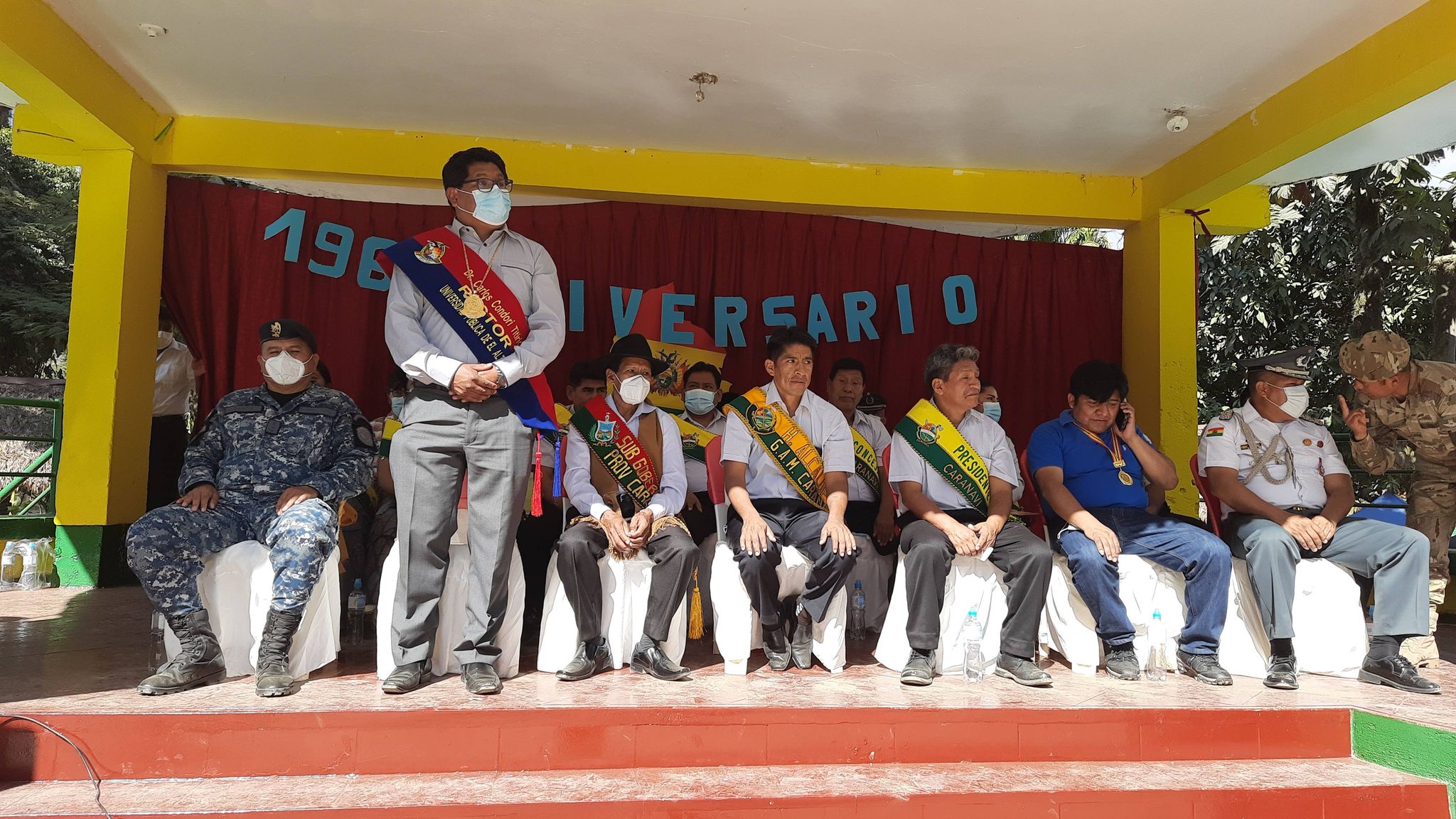 El Rector Condori estuvo portando una coqueta banda patriótica con los colores de la tricolor boliviana