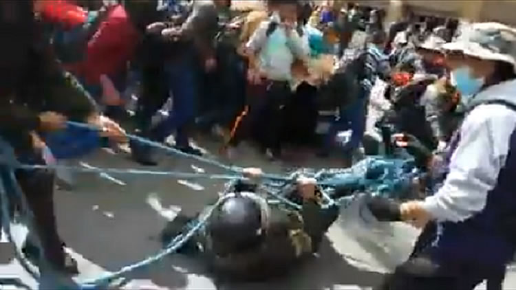Policía quedó amarrado e sus propias sogas y fue arrastrado por los marchistas.
