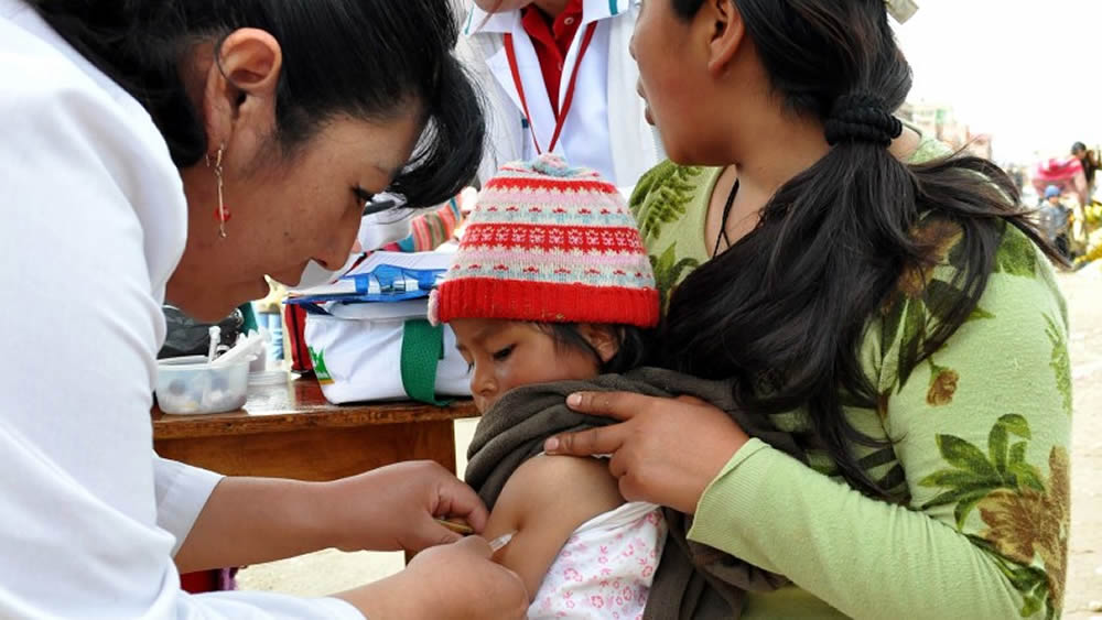 En El Alto vacunan a un niño con las Infecciones Respiratorias Agudas.